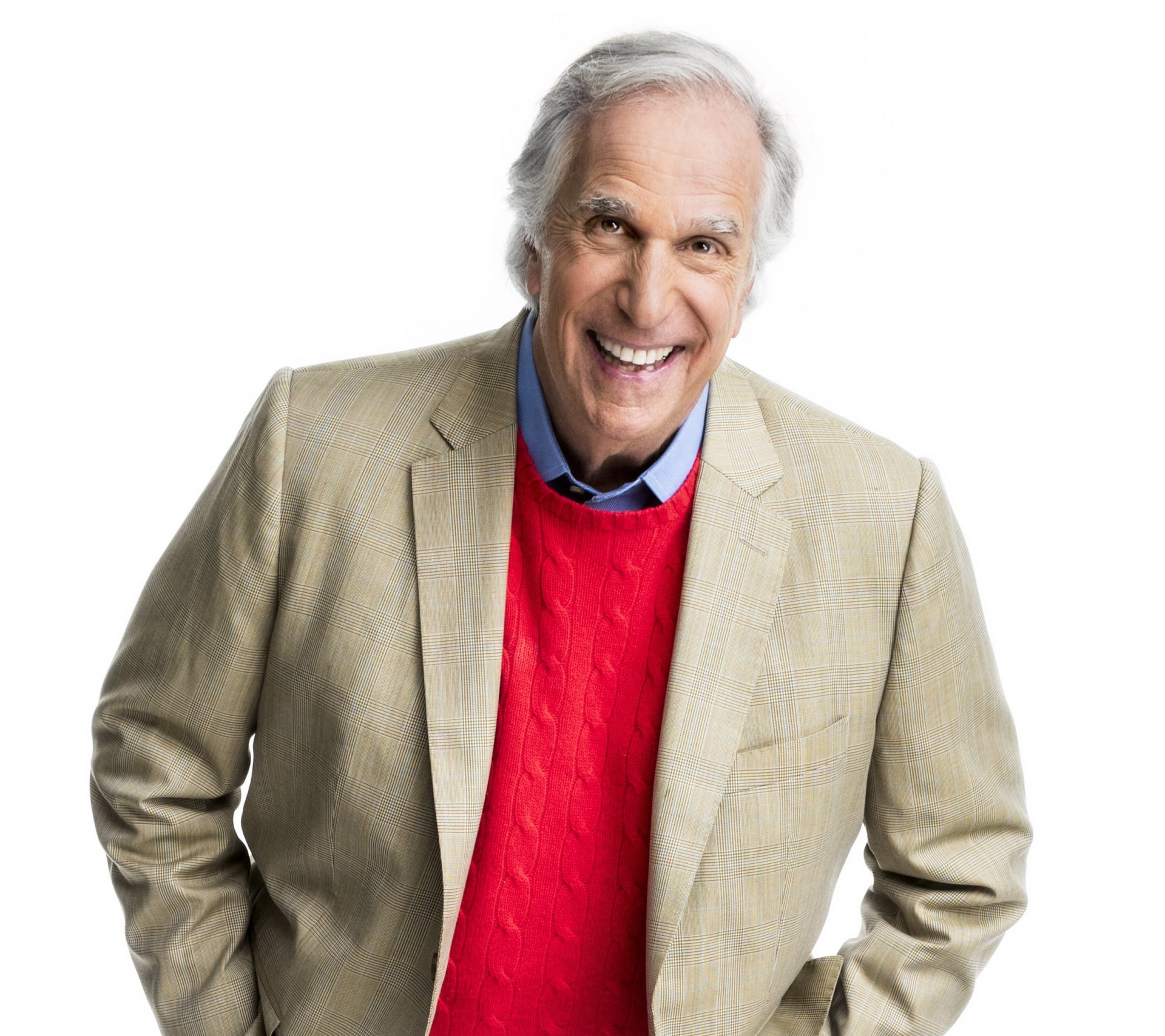Henry Winkler smiles with his hands in his jacket pocket