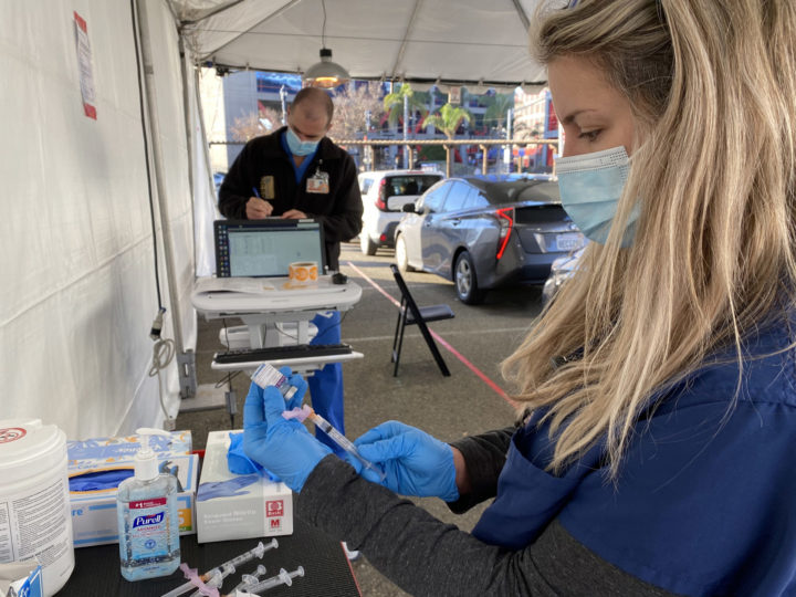 woman prepares vaccination at drive-through vaccination site