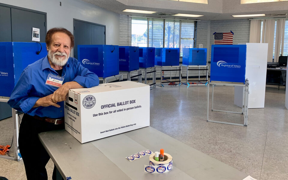 man stands with elbow on official ballot box