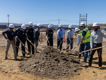 People holding shovels full of dirt over a pile of dirt for a groundbreaking ceremony.