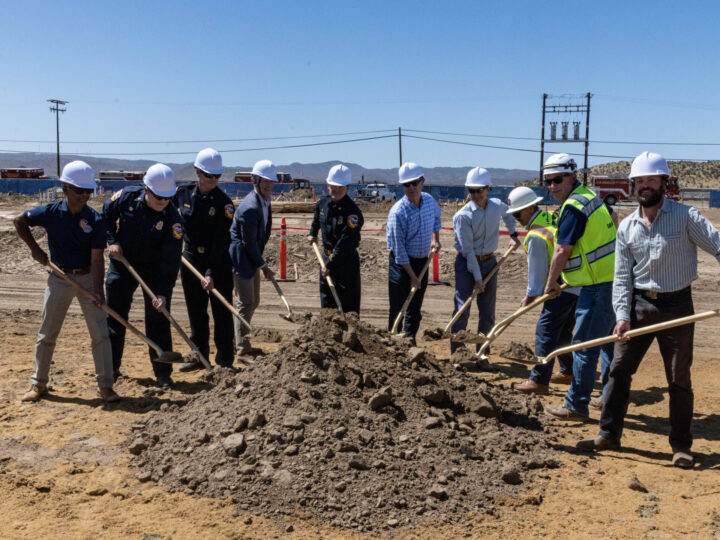 People holding shovels full of dirt over a pile of dirt for a groundbreaking ceremony.