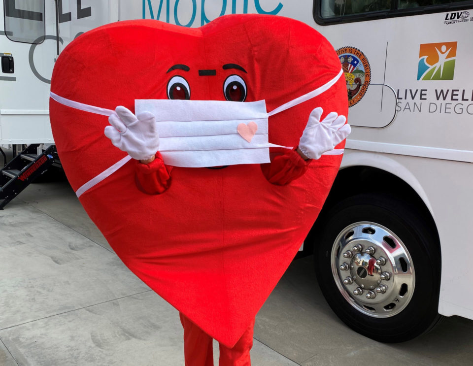 A heart-shaped mascot wearing face mask
