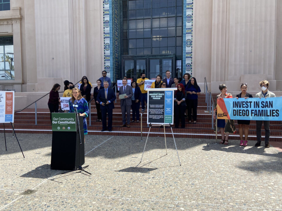 Supervisor Terra Lawson-Remer speaking at a news conference in front of supports for the Immigrant Legal Defense Program on the west side of the County Administration Building