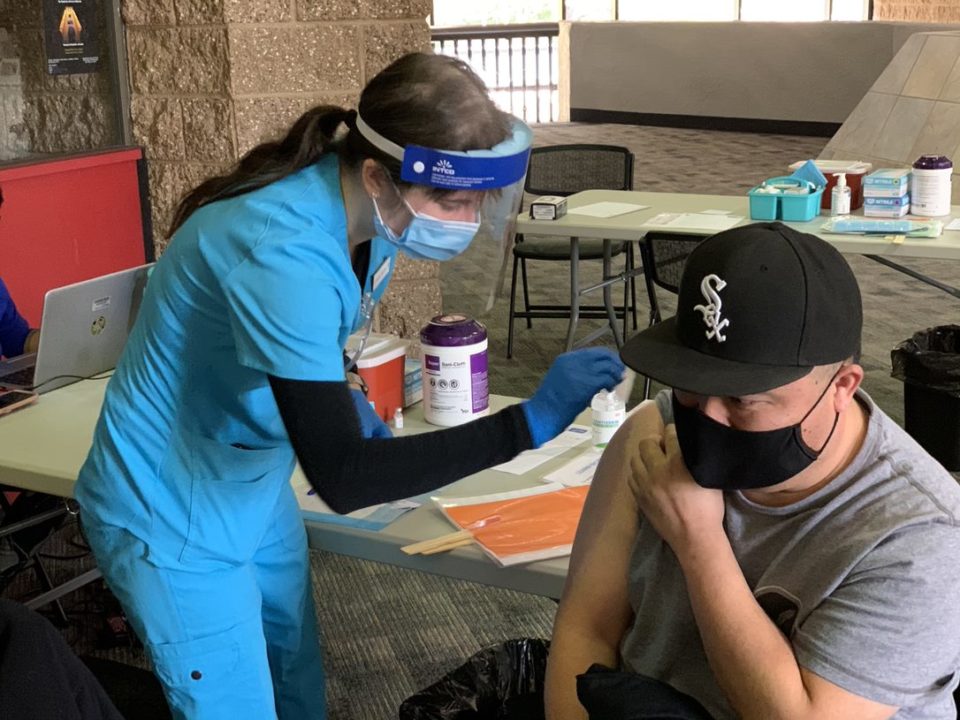 nurse prepares to give a man a vaccine