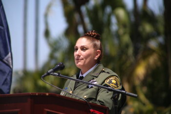 a uniforned deputy stands at a microphone