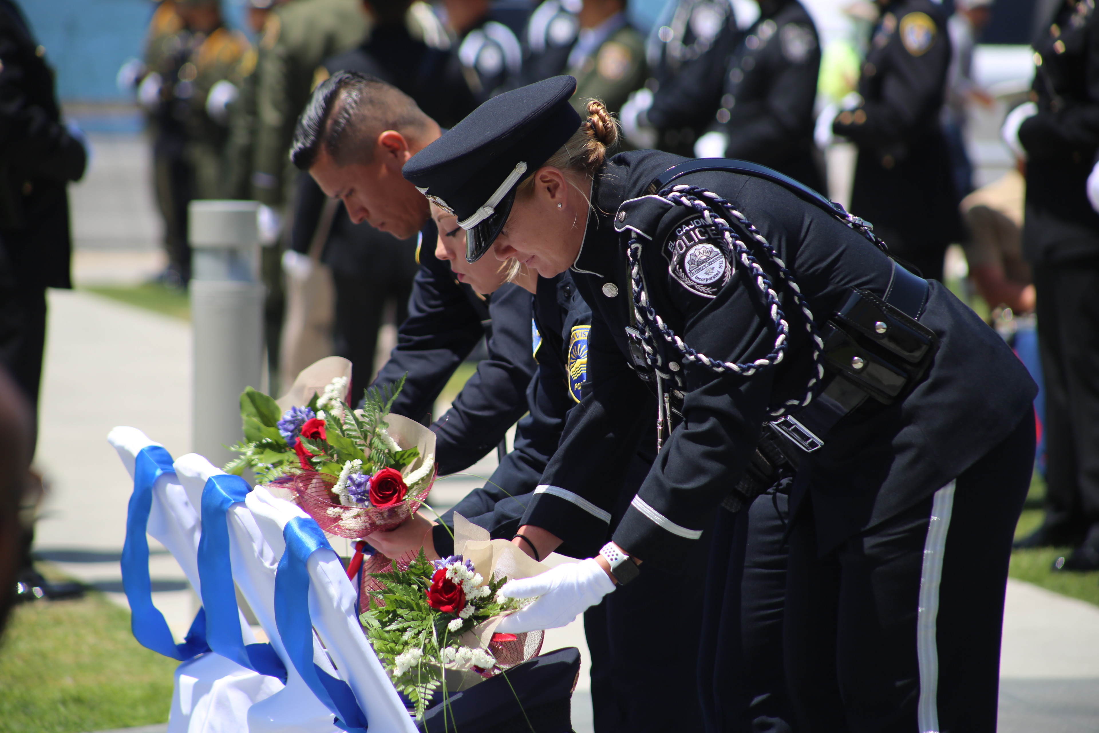 3 uniformed officers leave flowers on empty chairs