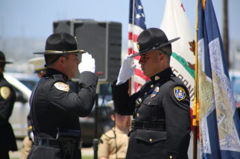 Two uniformed officers salute each other