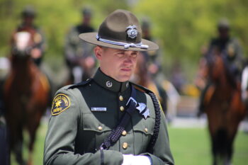 A sheriff deputy with horses in the foreground