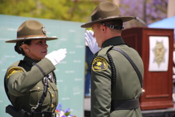 two uniformed law enforcement officers salture each other