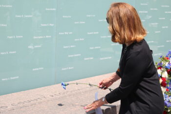 a woman with a flower sits in front of the Law Enforcement Memorial