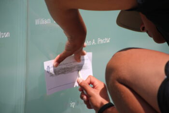 a person traces a name engraved on the Law Enforcement memorial