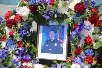 a photo a law enforcement officer with flowers all around it