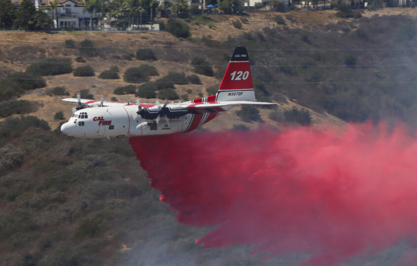 CAL FIRE C-130 Hercules firefighting tanker performing a retardant drop on the Sorrento Fire