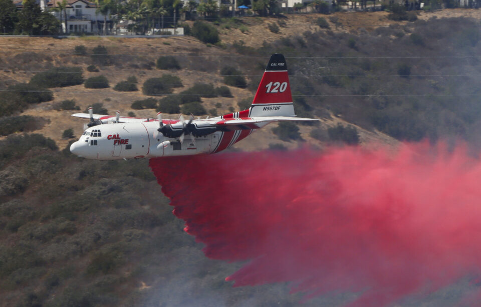 CAL FIRE C-130 Hercules firefighting tanker performing a retardant drop on the Sorrento Fire