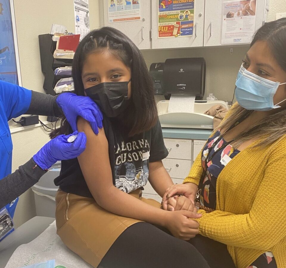 young child gets vaccine in doctor's office