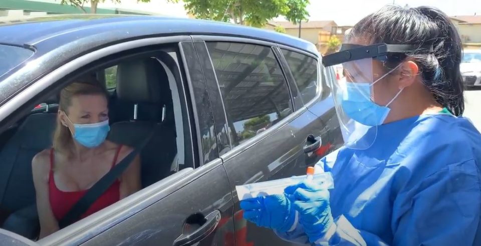 woman in car waits to get a coronavirus test
