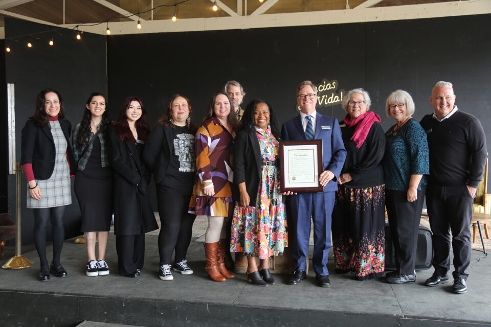 people stand on a stage smiling