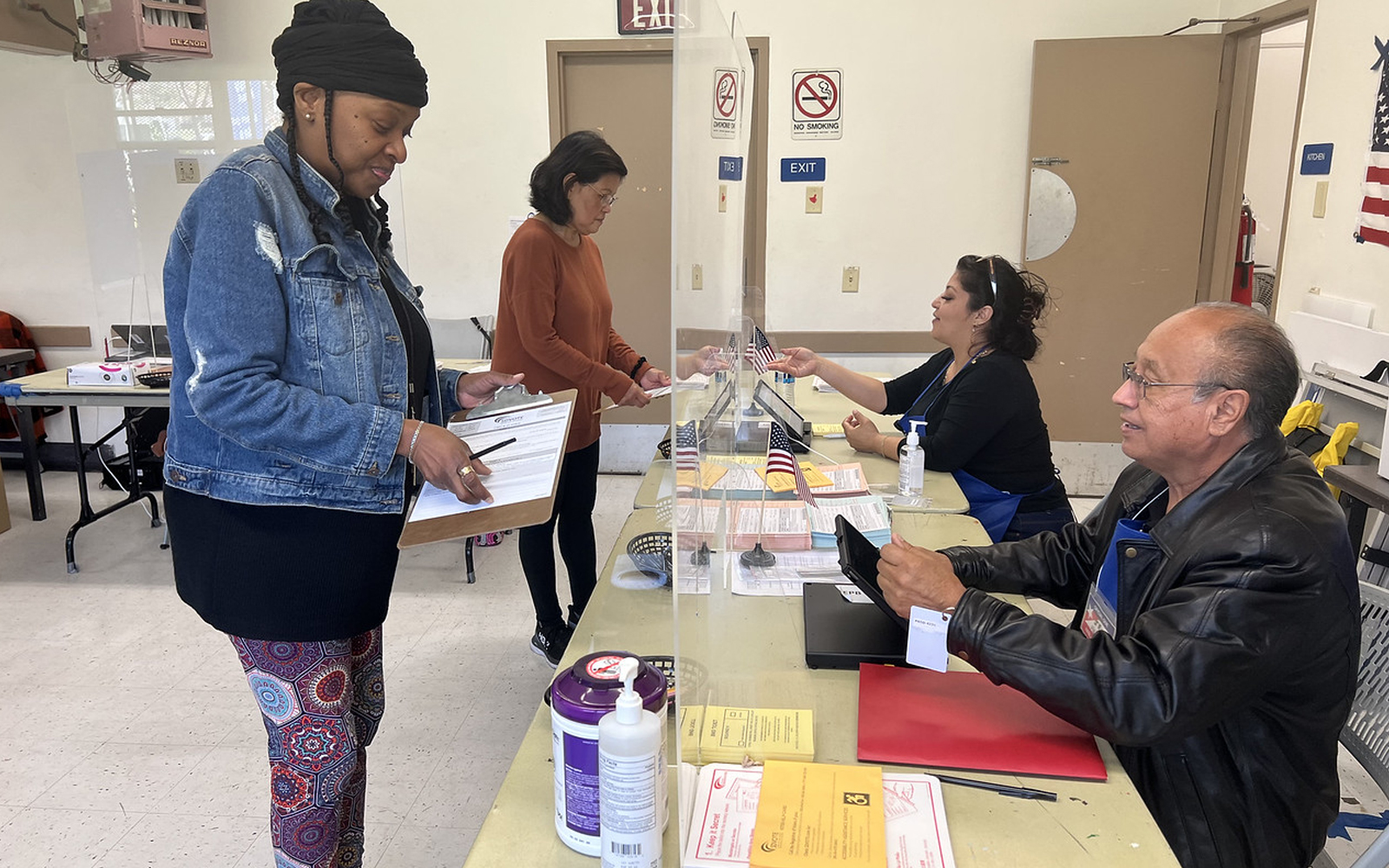 two voters at table with two poll workers