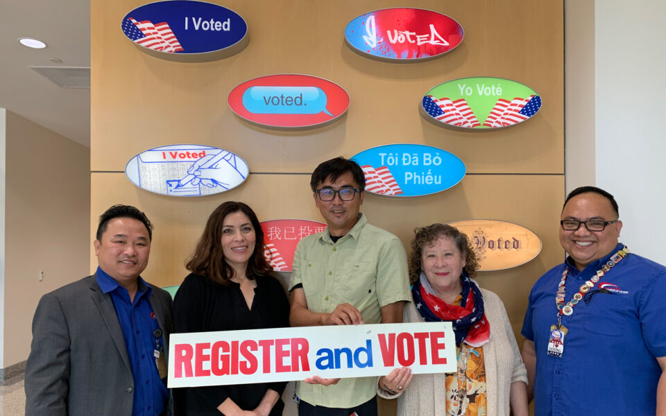 employees standing in front of a wall of large voting stickers