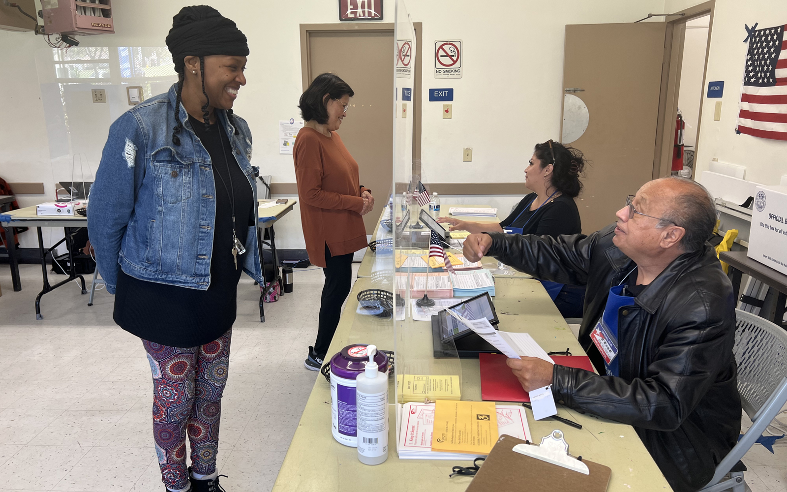 two voters are helped at table in polling location