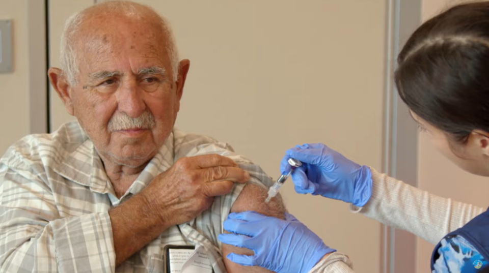 Man receives flu vaccine from public health nurse