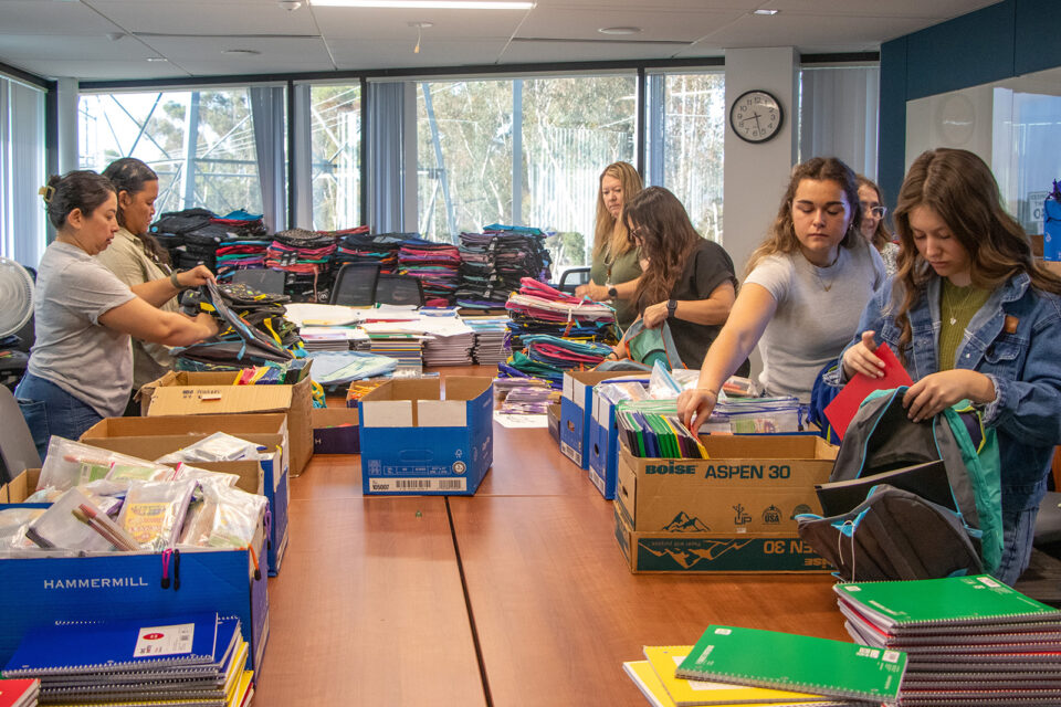Stuffing backpacks with school supplies