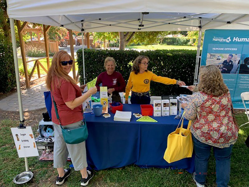 People at an Animal Services table at community fair