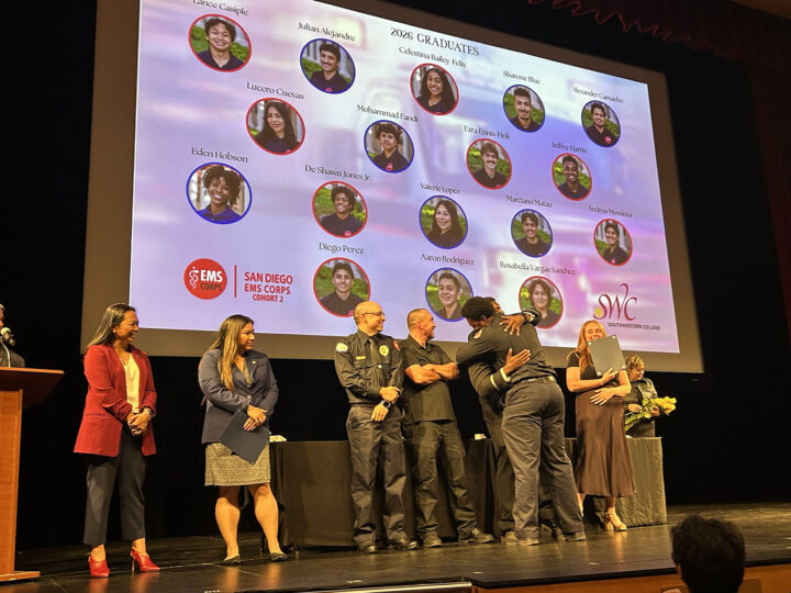 EMS graduate hugs a mentor on a stage