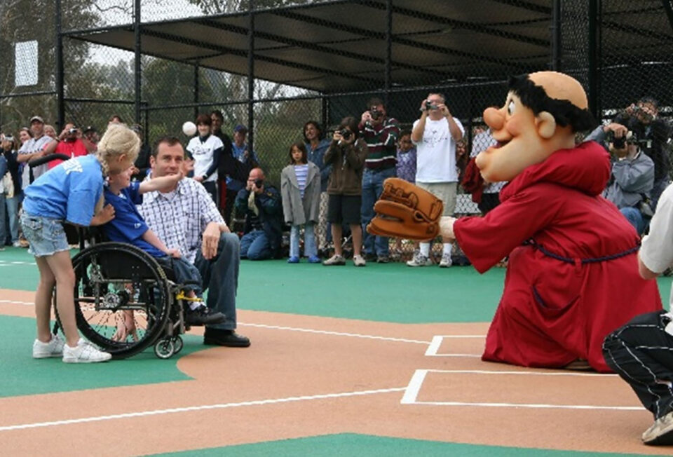 person throws out a pitch to the Padres mascot