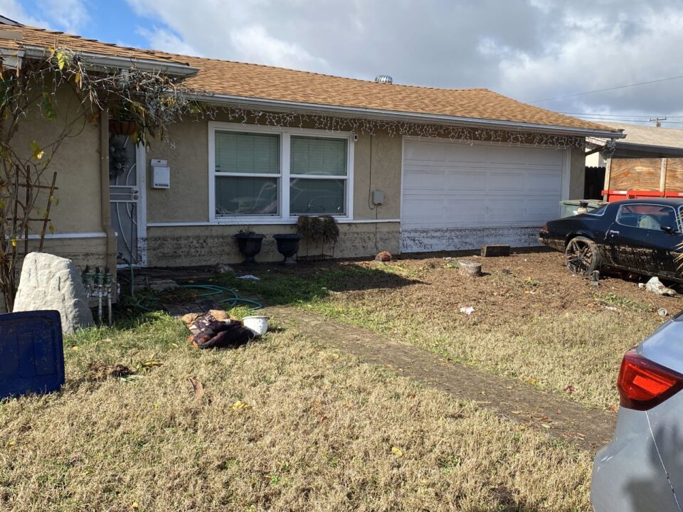 water damaged house with mug in yard