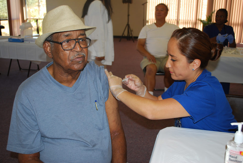 A Black man gets a flu shot.