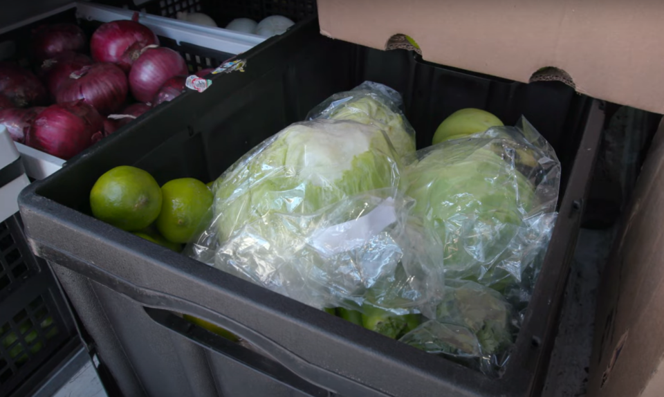 Fresh produce including lettuce and limes in delivery bin