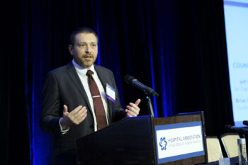 San Diego County EMS Program Coordinator Brian Christison on stage accepting Community Leadership Award