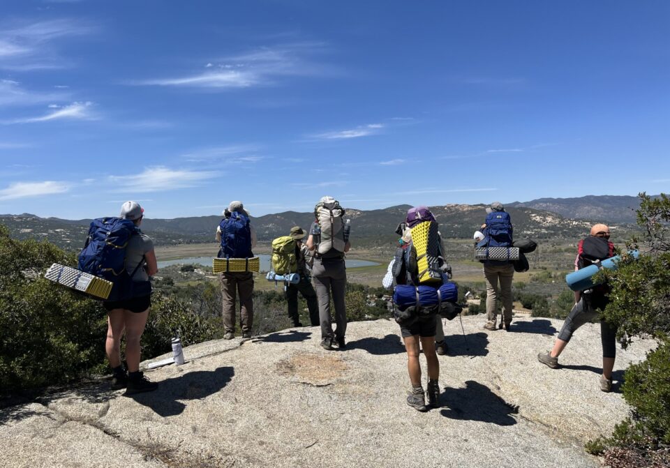 Hikers at a summit looking off in the distance