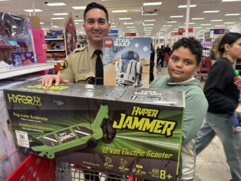 Un ayudante del sheriff y un nio en una tienda con un evento policial.