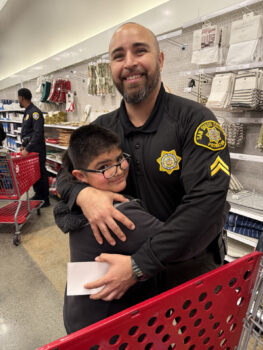 Oficial de libertad condicional y nio en el evento "Shop with a Cop".