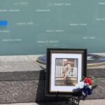 Photo of fallen officer in front of memorial wall