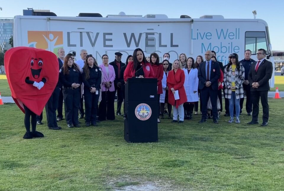 Chairwoman Nora Vargas and community members stand in front of Live Well bus at press conference on Love Your Heart