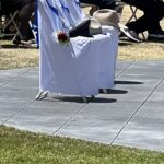 Hats of fallen officers on chairs in front of memorial wall