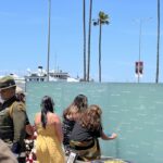 Woman and child kneeling in front of memorial wall