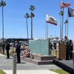 Officers standing in front of memorial wall