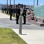 Uniformed law enforcement stands in a line near the Law Enforcement Memorial
