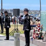 Officers standing in front of memorial wall