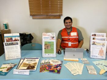 A representative from Aging & Independence Services smiles at a table