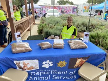 a representative from Animal Services smiles at a table