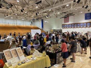 Overview of West Hills High gym with Santee Children's Business Fair tables in place
