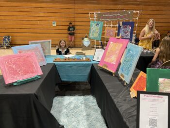 Overview of West Hills High gym with Santee Children's Business Fair tables in place