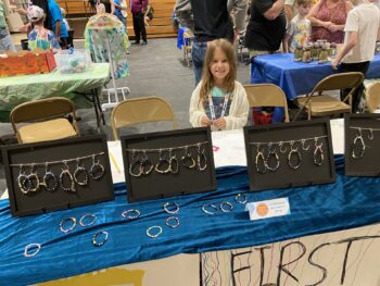 Overview of West Hills High gym with Santee Children's Business Fair tables in place