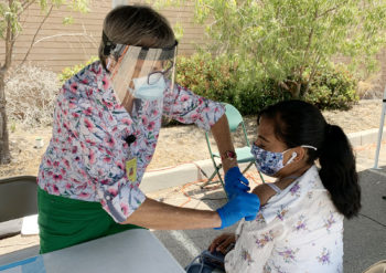 A woman receives her COVID-19 vaccine at a mobile vaccination site.