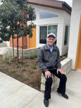 Senior seated outside his apartment